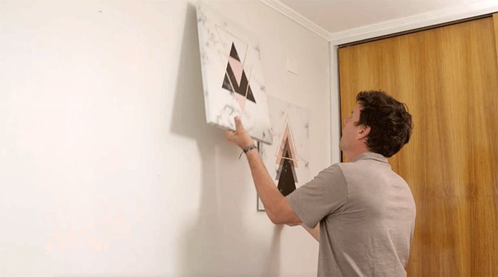 un hombre retira los cuadros decorativos de la pared antes de pintar el cielo y el muro