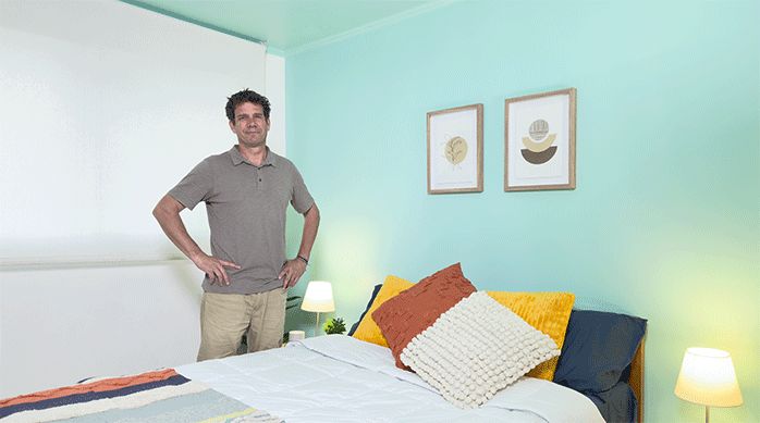 un hombre en una habitación recién pintada para que se vea más amplia