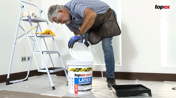un hombre abre un tarro de látex