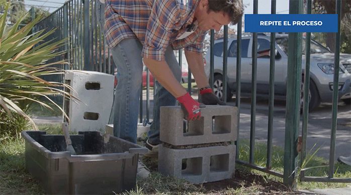 un hombre pone un ladrillo de concreto sobre la base de la banca