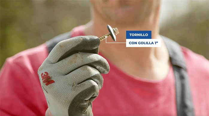 un hombre sostiene con la mano un tornillo con golilla de 1".