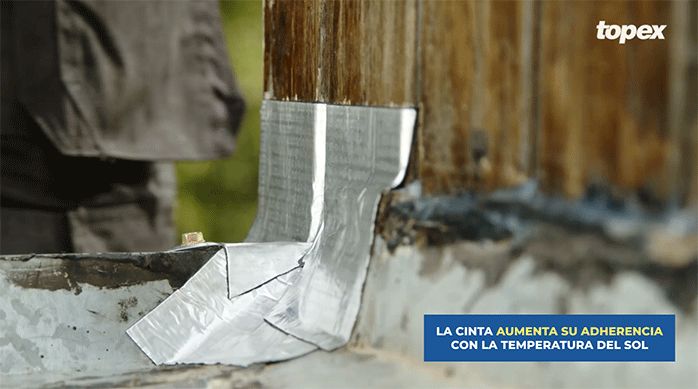 se ve un pedazo de cinta tapagoteras Topex sellando la unión entre el muro y la techumbre.