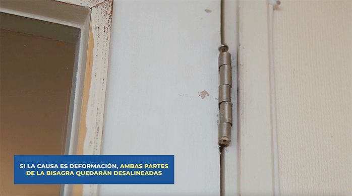 una bisagra deformada en una puerta que no cierra bien.