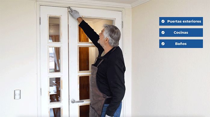 un hombre muestra cómo una puerta choca con el marco en la parte superior.