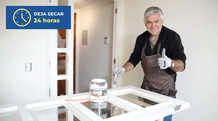 un hombre pinta una puerta con una brocha y esmalte al agua.