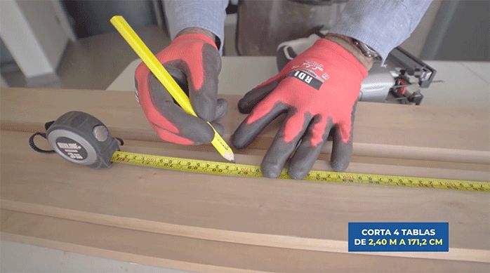 un hombre marca una tabla de roble vaporizado con un lápiz para luego cortarla con una sierra caladora.