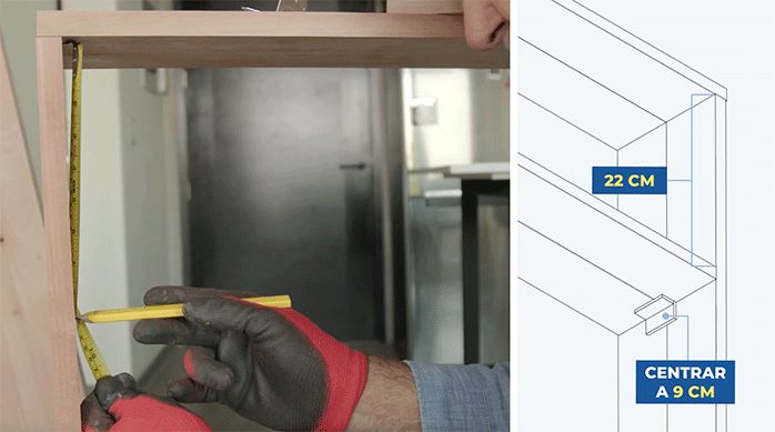 un hombre marca 22 cm libres bajo la cubierta del mueble de arrimo para fijar las escuadras.