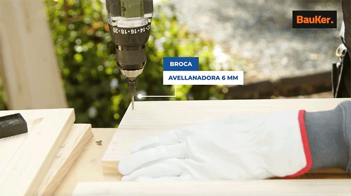 un hombre perfora un trozo de madera laminada con una broca avellanadora de 6 mm.