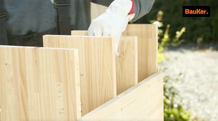 un hombre pone las repisas interiores de un mueble organizador para lavamanos.