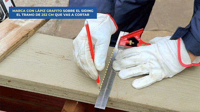 un hombre marca una tabla de siding de fibrocemento con una escuadra