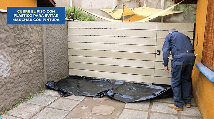 un hombre pone un protector plástico en el piso.