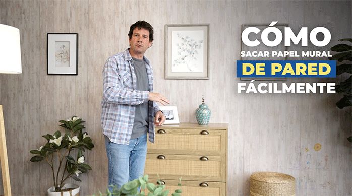un hombre con ropa casual en un living con un muro con papel mural.