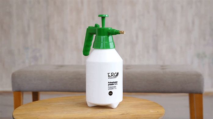 pulverizador de agua sobre una mesa de madera listo para sacar papel mural fácilmente.