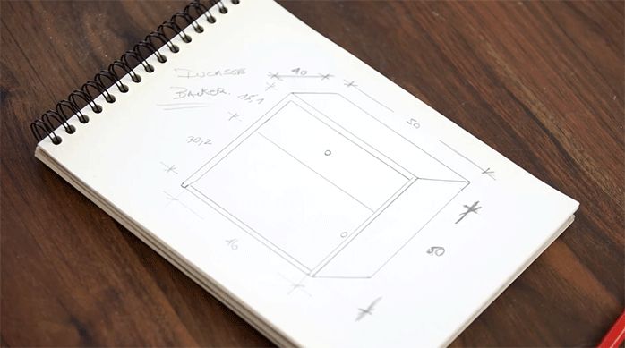 se ve una croquera con el dibujo o bosquejo de un mueble con sus medidas.