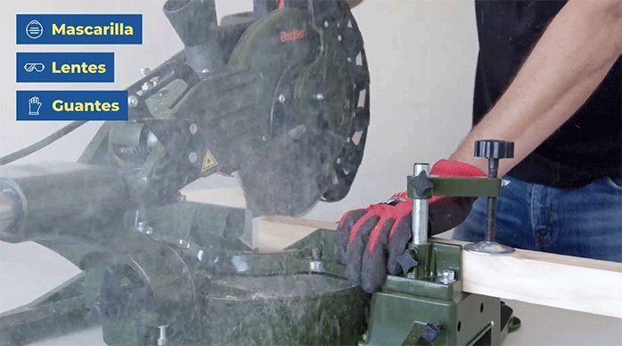 un hombre corta un trozo de pino seco cepillado con una sierra ingleteadora.