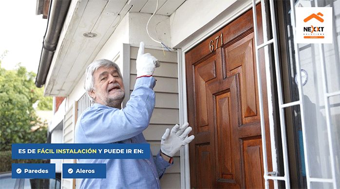 un hombre muestra la conexión eléctrica que existe en la entrada de una casa para instalar una cámara de seguridad inteligente.