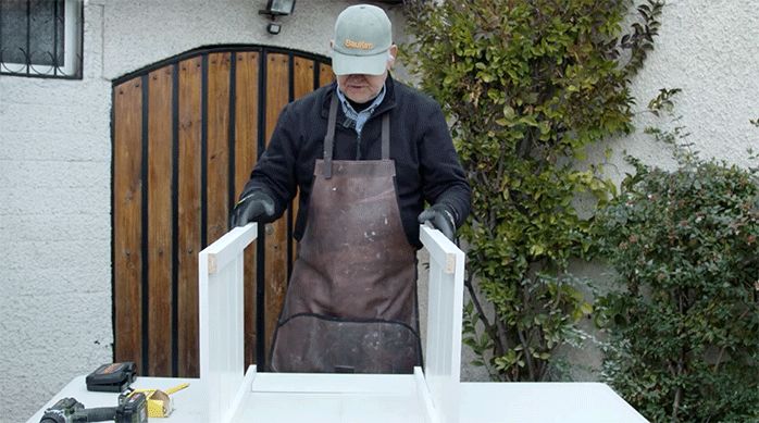 un hombre muestra los laterales del mueble de cocina.
