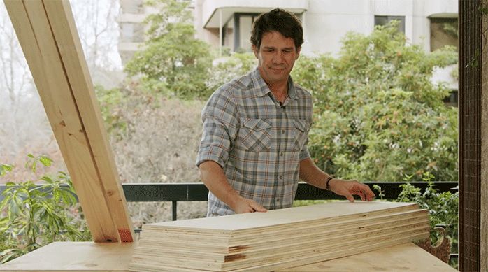 un hombre acomoda el terciado mueblista y los listones de pino seco cepillado para empezar a construir el mueble de madera y metal.
