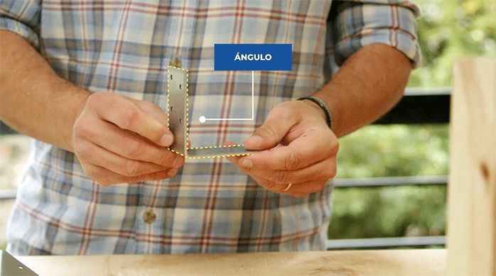 un hombre sostiene un ángulo de acero galvanizado marca simpson.