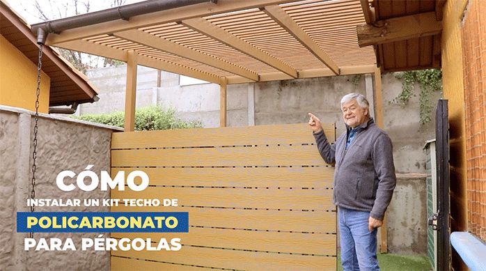 un hombre apunta con el dedo hacia un cobertizo de madera o pérgola de madera.