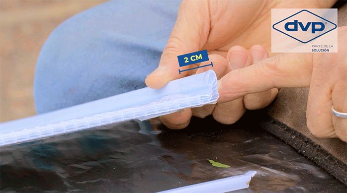 un hombre muestra la esquina de una plancha de kit de policarbonato alveolar.