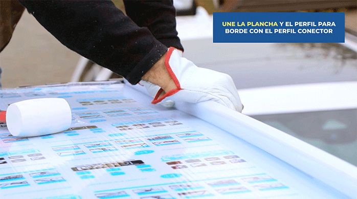 un hombre pone el perfil conector para unir la plancha de policarbonato alveolar al techo.
