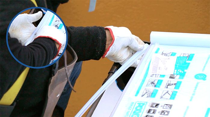 un hombre instala el cubre zócalo en el borde de la plancha del kit de policarbonato alveolar para pérgolas.