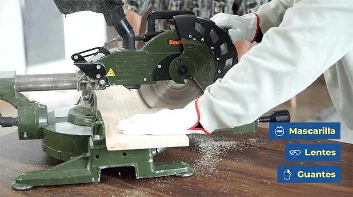 un hombre corta un trozo de madera usando una sierra ingleteadora.