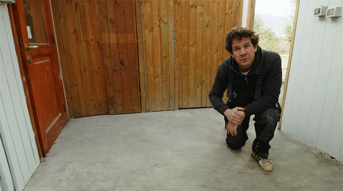 un hombre sobre un radier reparado con mortero de reparación. Antes tenía grietas y fisuras.