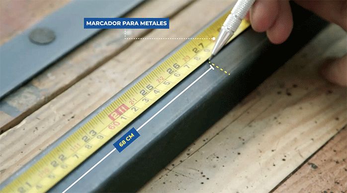 una persona usa un marcador de metales para marcar un perfil metálico.