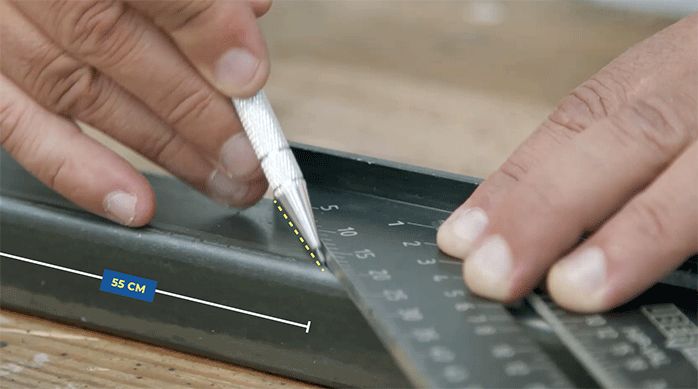 una persona usa un marcador para metales para marcar un perfil metálico.