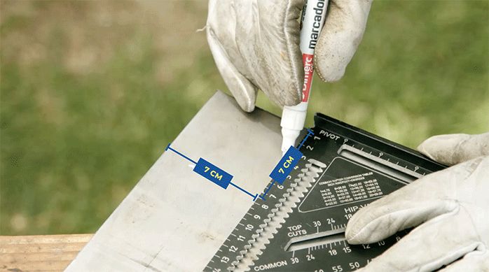 una persona marca un cuadrado de 7 x 7 en una de las esquinas de una plancha metálica.