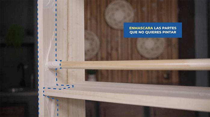 se ve el librero con cinta de enmascarar para proteger las partes que no se quieren pintar.