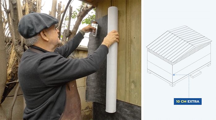 un hombre fija una malla de super fieltro usando una engrapadora en el exterior de una casa.