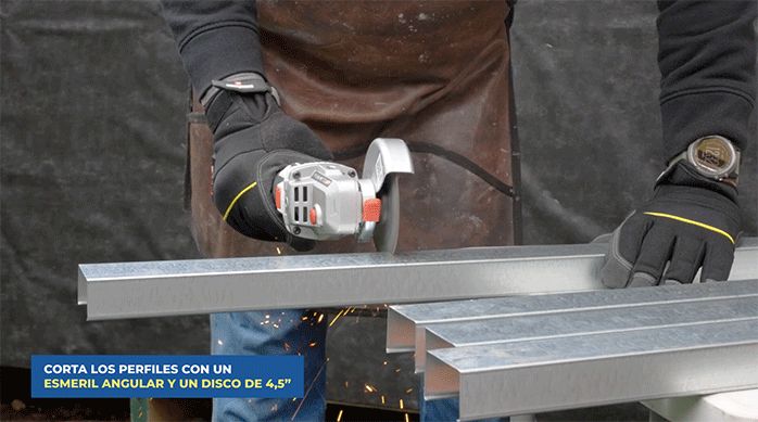 una persona corta un perfil de metalcon con un esmeril angular con disco de 4,5".