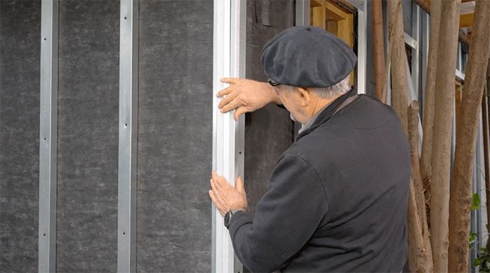 un hombre presenta los perfiles J en la esquina de la casa.