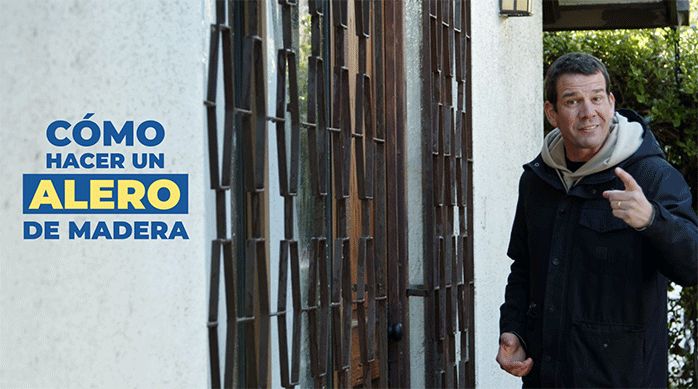 un hombre frente a la entrada de una casa listo para enseñar a cómo hacer un alero de madera.