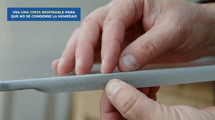 un hombre pone cinta protectora para proteger el canto del policarbonato alveolar.
