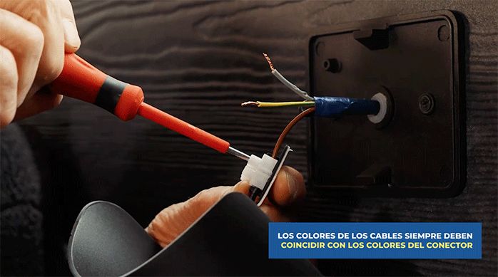 una persona conecta los cables del apliqué a los cables de la red eléctrica.