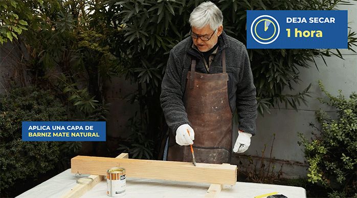 un hombre aplica barniz mate natural en un trozo de madera.