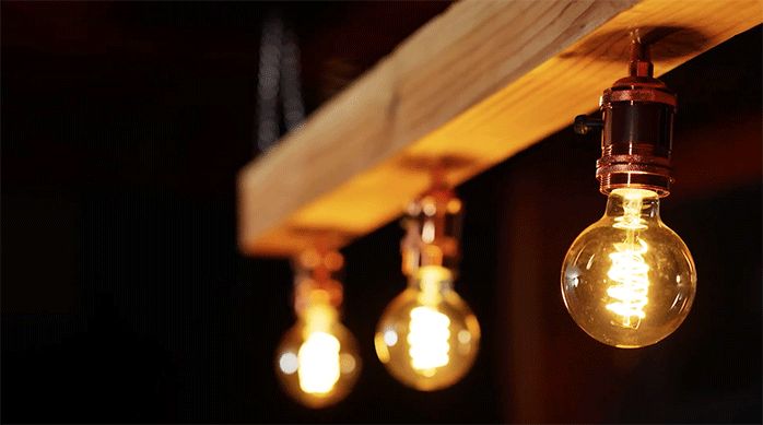 una lámpara colgante de madera con 3 luces con ampolletas led.