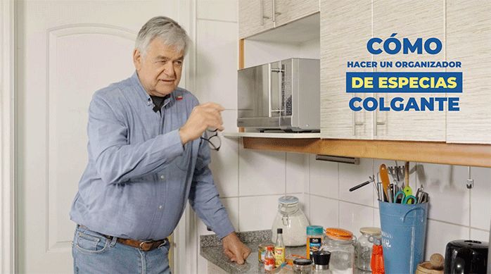 un hombre en una cocina listo para enseñar a cómo hacer un especiero colgante u organizador de especias para cocina.