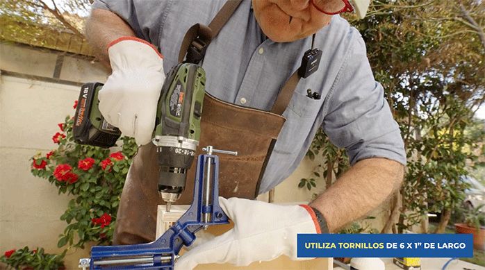 un hombre fija una unión entre trozos de madera con tornillos y prensa esquina.