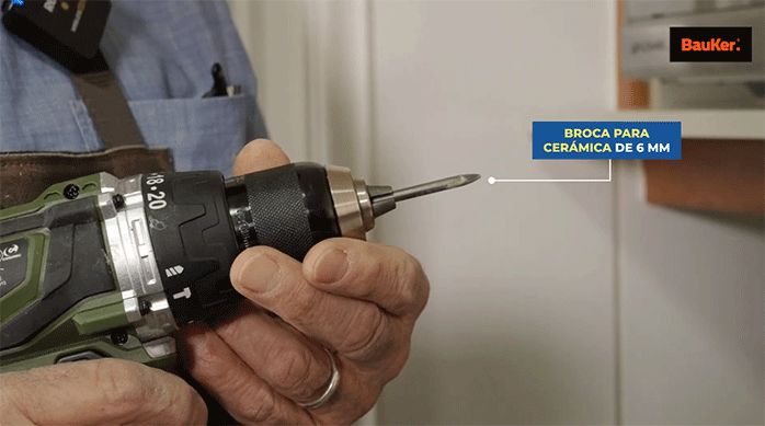 una persona sostiene un taladro con una broca para cerámica de 6 mm.