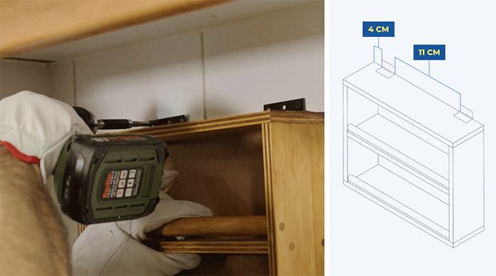 una persona atornilla las bisagras del especiero colgante en la pared de la cocina.
