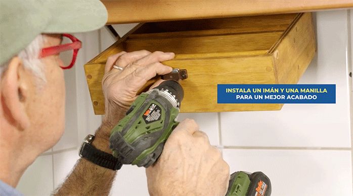 una persona instala un imán en el especiero colgante.