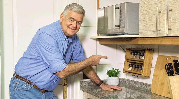 un hombre señala el nuevo especiero colgante en una cocina.