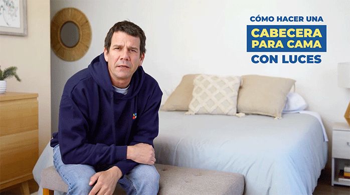 un hombre sentado en una cama listo para enseñar cómo hacer una cabecera para cama con luces led.