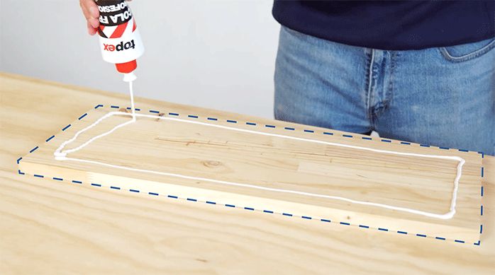 un hombre aplica cola fría en una repisa laminada predimensionada de madera.
