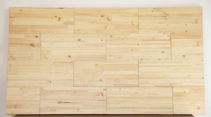 una base de terciado de madera con repisas laminadas pegadas en su superficie para crear un respaldo o cabecera para cama.